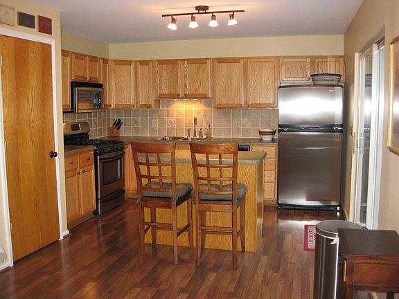 Remodeled kitchen contains stainless appl, Pergo flrs, tile backsplash, island