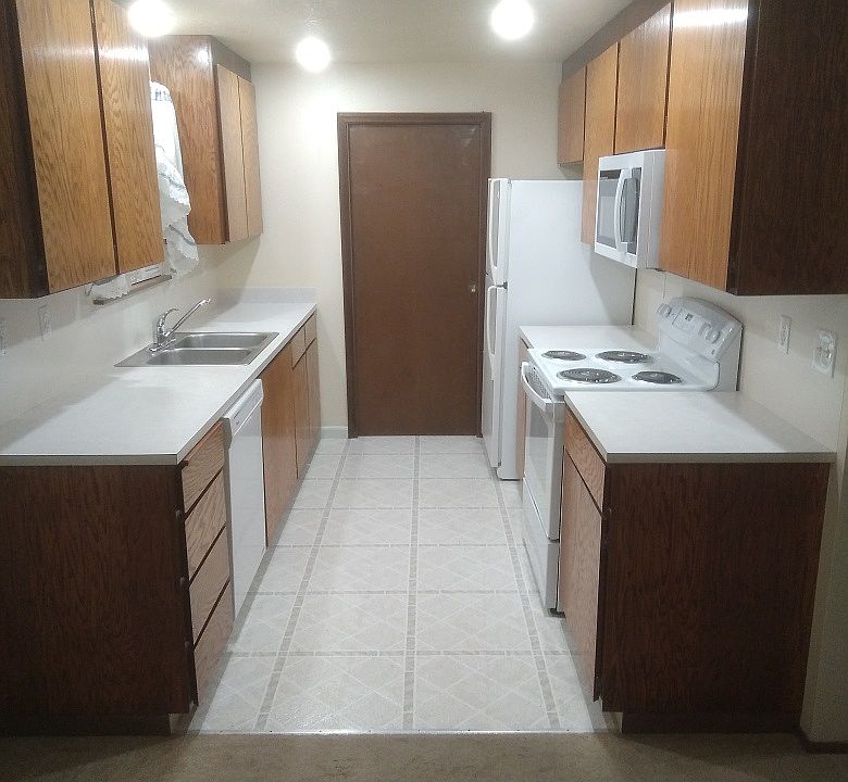 Kitchen with NEW lighting, NEW miniblinds, NEW self-cleaning stove, NEW microwave, refrigerator, dishwasher, pocket door to laundry room, Inlaid vynal flooring