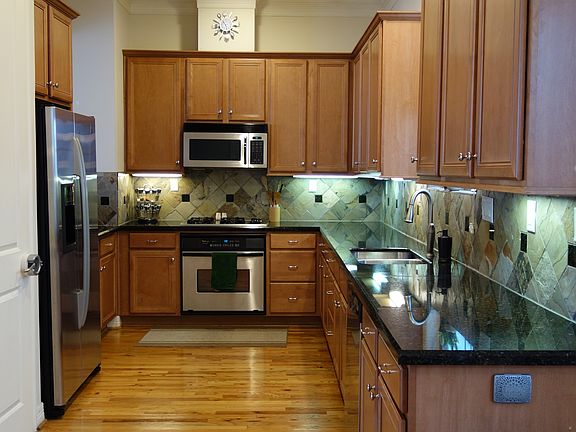Galley Kitchen with hardwood floors, stainless steel applian