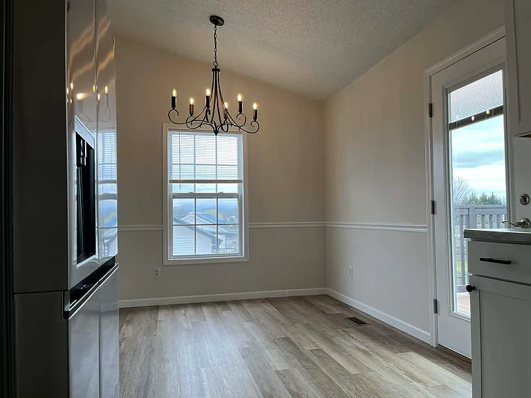 Dining area near kitchen and living room with gorgeous chandelier