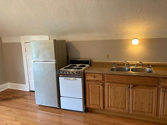 Kitchen #3 showing fridge, stove, cabinets