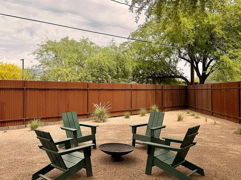 Private fenced backyard with fire pit and outdoor seating.