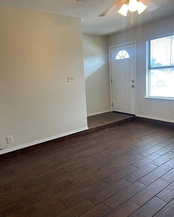 Foyer featuring ceiling fan, a textured ceiling, and dark wood finished floors