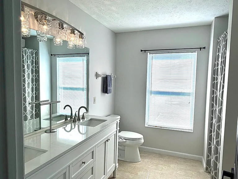 En-suite primary bath with large window for lots of light, generous extra storage area, tub/shower combo. New double bowl vanity with marble top and new modern lighting.