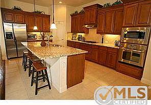 Over sized granite island and stainless steel appliances.