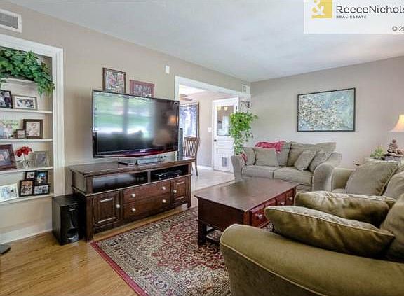 COMFORTABLE LIVING ROOM WITH LOVELY HARDWOODS.