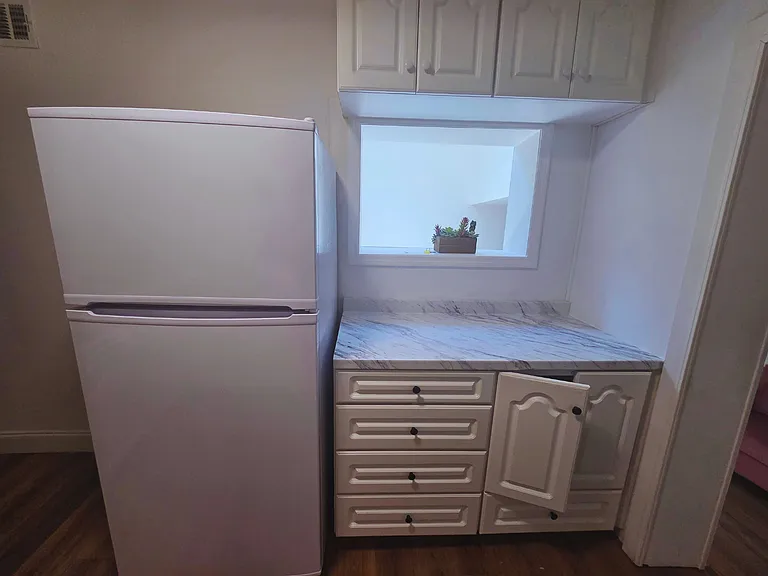 Full-size fridge and spacious cabinets for convenient food storage.