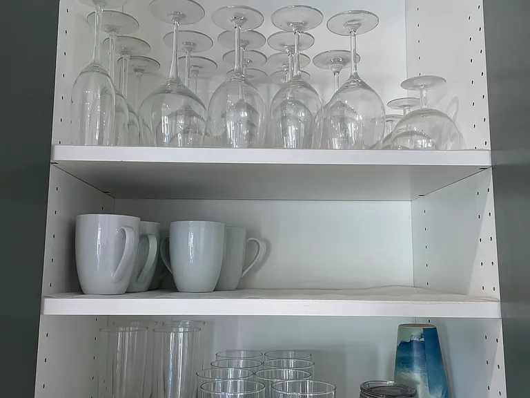 Dishes, glasses and stemware in fully stocked kitchen.