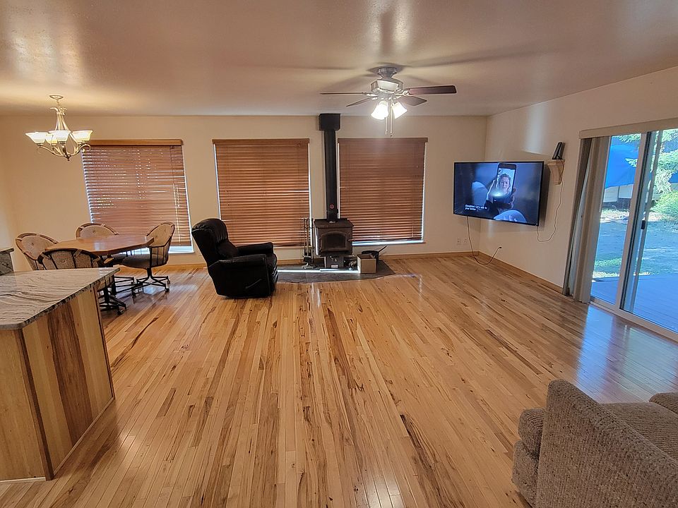 Great room with Hickory hardwood floors, wood stove, and view of the adjacent taxiway.