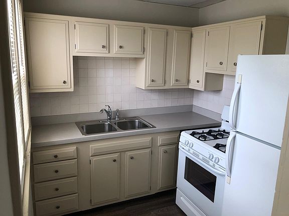 Kitchen with new countertop and backsplash with gas stove and refrigerator