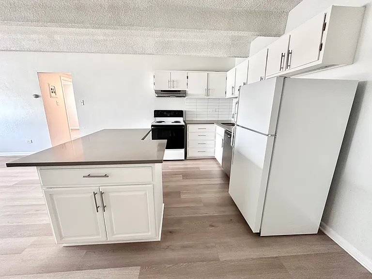 Bright, modern kitchen with sleek white cabinetry, spacious island, and contemporary appliances. Bright, modern kitchen with sleek white cabinetry, spacious island, and contemporary appliances.
