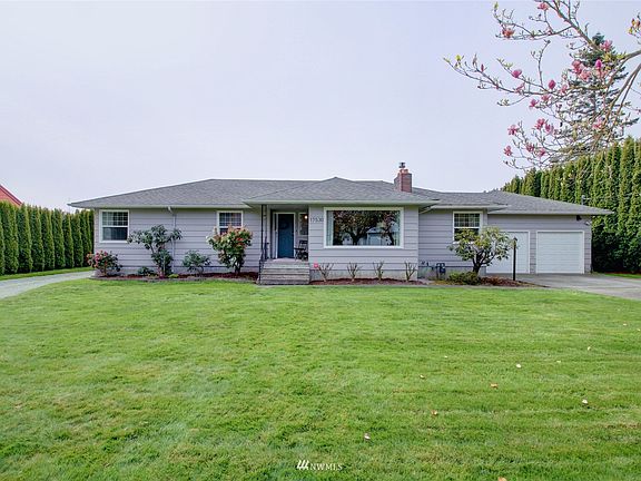 Front view. There is lovely curb appeal as trees are flowering and spring plants are coming to life. 