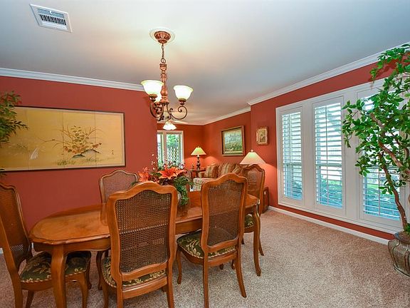 Recent carpet, crown molding and Plantation shutters enhance the formal dining room where many memories will be made.