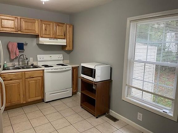 Kitchen (more cabinets along left wall, next to refrigerator).