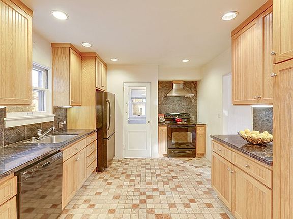 Remodeled cooks kitchen with wood cabinets, granite counter tops, Italian marble tile floor, under counter lights, stainless steel sink and vent for stove.