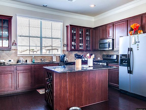 Open kitchen with upgraded cabinets, wine rack and lots of granite