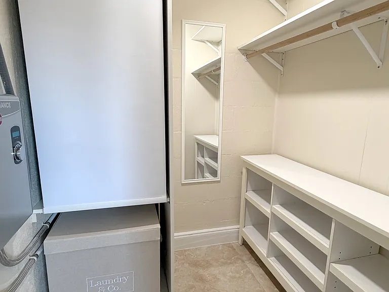 This spacious closet features built_in shelving and generous storage space. (Left of photo: AC Unit/Instant Water heater)