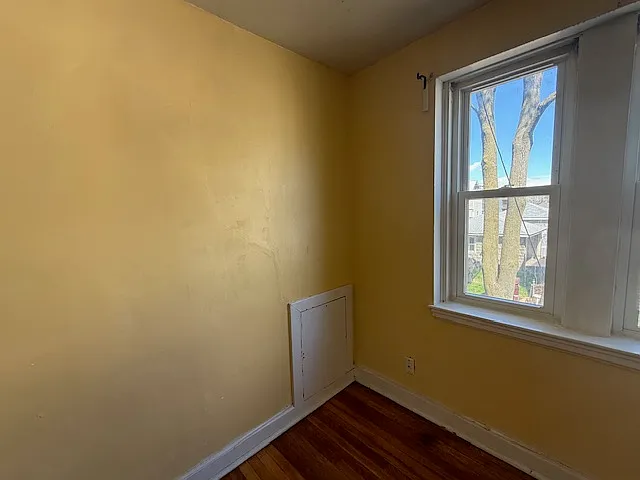 Living room. The lower portion of one wall contains a maintenance access panel (maintenance block) used to service plumbing pipes inside wall.