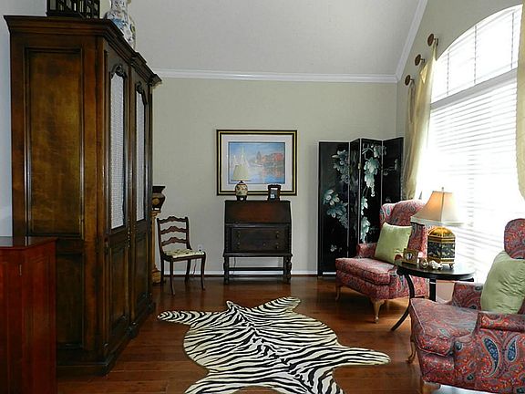The formal living room can be used as a study and features wood flooring and crown moulding.