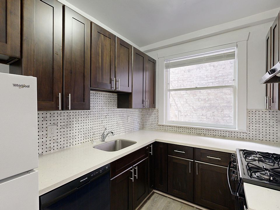 Kitchen with cabinets, refrigerator, stove, range hood, and sink