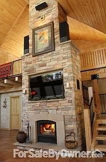 Inside living room main level
						:
						Bookshelves, floor to ceiling windows, tile & stone fireplace.