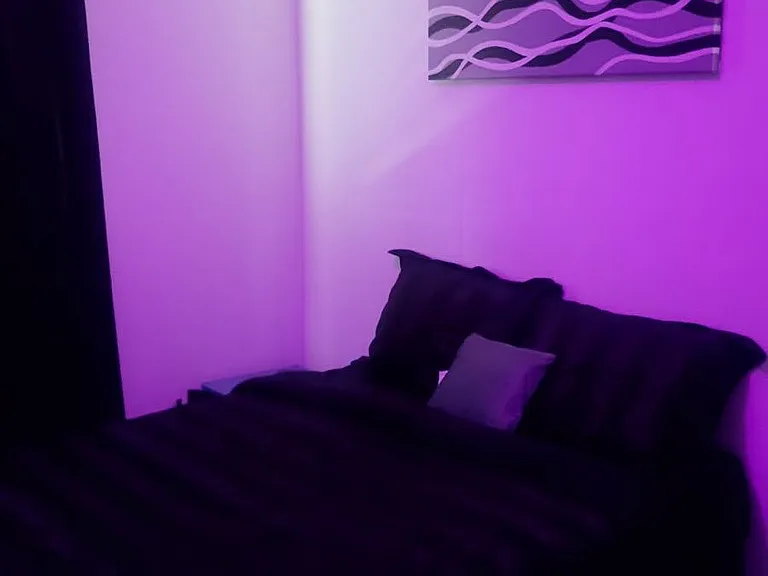 Private bedroom with a comfortable bed setup, blackout curtains, and wall art for a finished feel.
