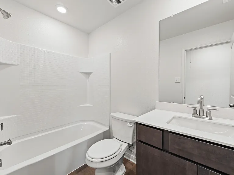 The secondary bathoom has a large vanity space and shower-tub combo.