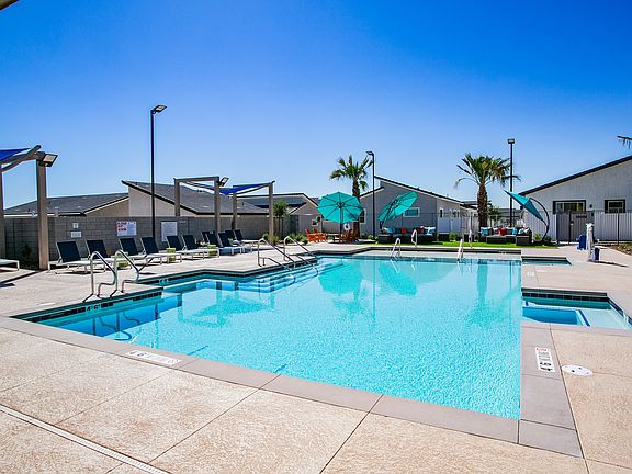 Relax by the poolside in a serene, sun-filled environment perfect for leisure and comfort.