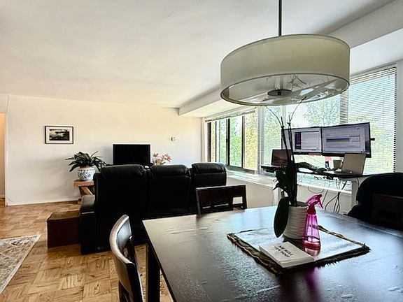 View from the dining room, with the adjustable desk to the right and the living room up ahead. The kitchen is to the left.