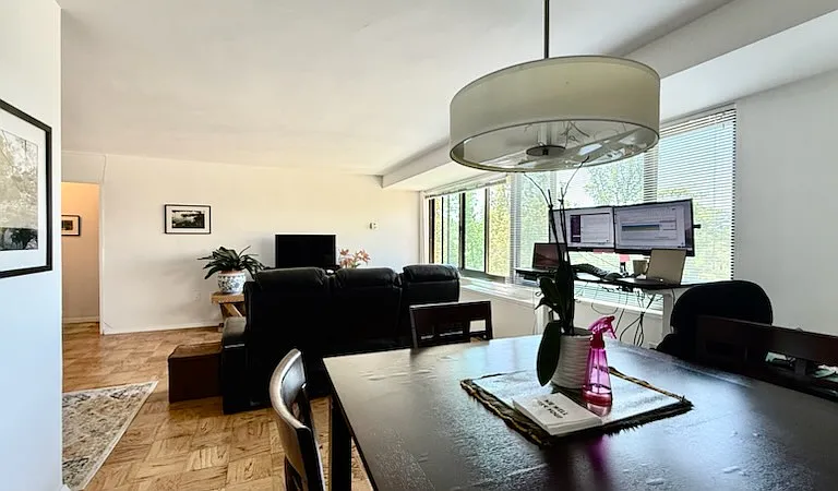View from the dining room, with the adjustable desk to the right and the living room up ahead. The kitchen is to the left.