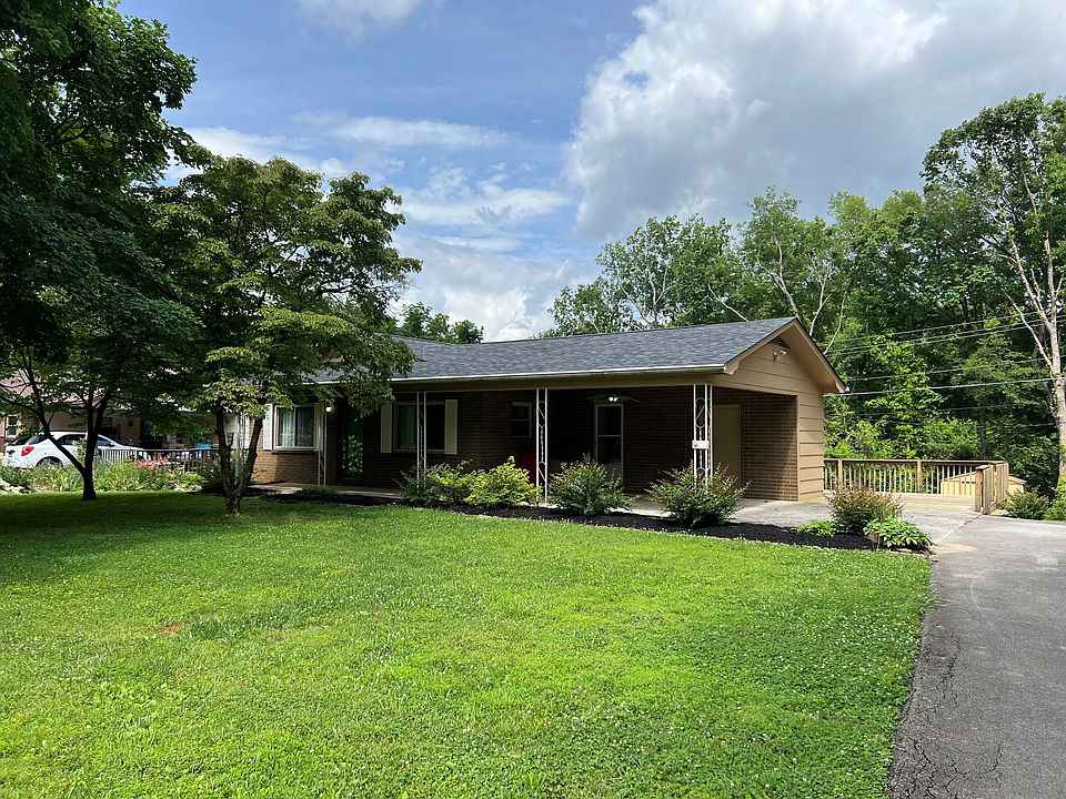 Exterior showing carport, side deck, lawn.