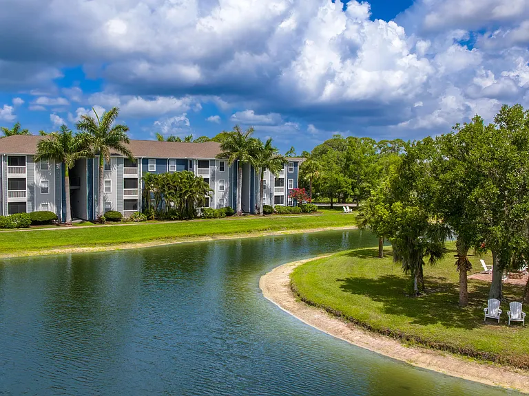 Experience the beauty of waterfront living at Grand Oaks with picturesque views, tropical landscaping, and inviting outdoor seating.