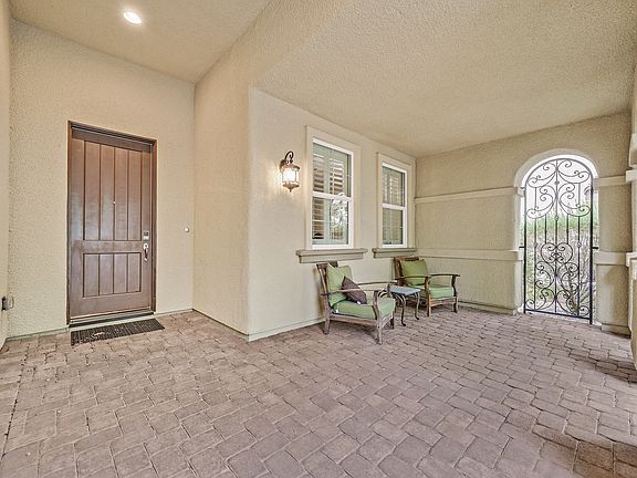 Large covered front patio with gated entry.