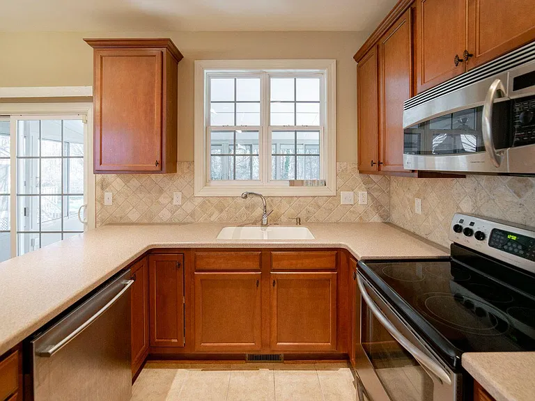 KITCHEN GALLEY WITH VIEW OF FOUR-SEASON SUNROOM