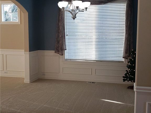 Formal dining room with large picture window for lots of light. Arches, wainscoting and coved ceiling for warm elegance. Opens and connects with formal living room