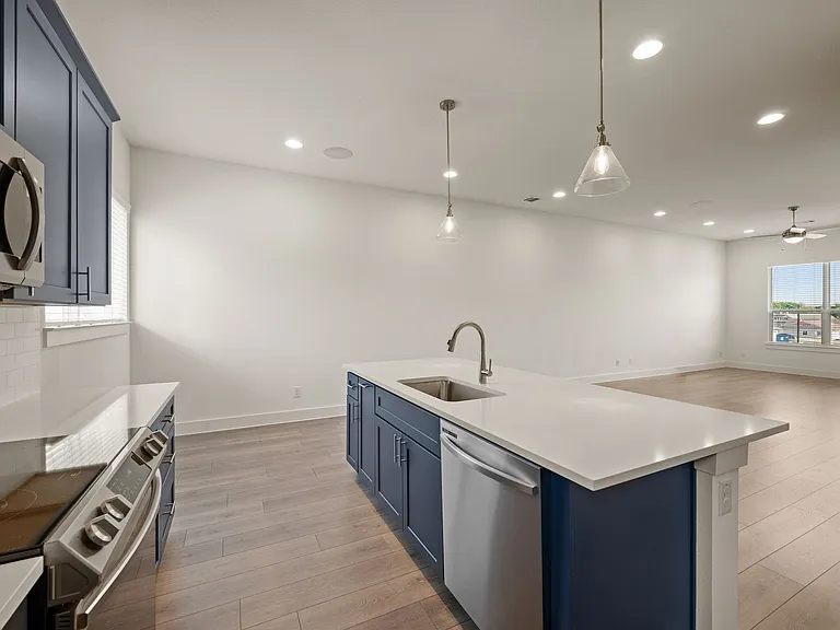 Kitchen view with beautiful island that seats four with elegant pendant lighting. Ample cabinets for extra storage.