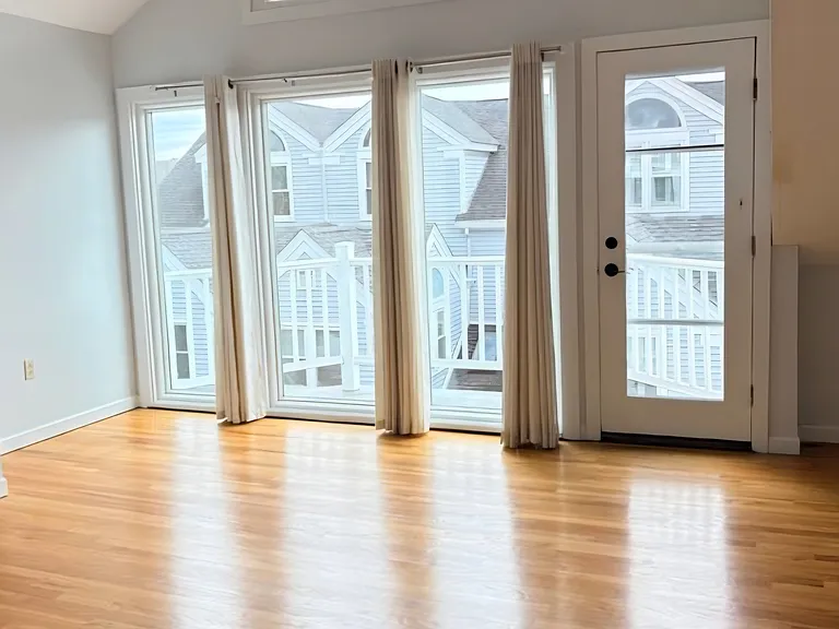 Bright and spacious living area with vaulted ceilings, hardwood floors, and abundant natural light.