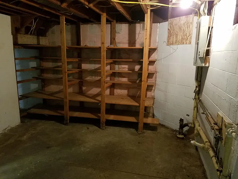 Full unfinished basement with storage and washer/dryer hooku