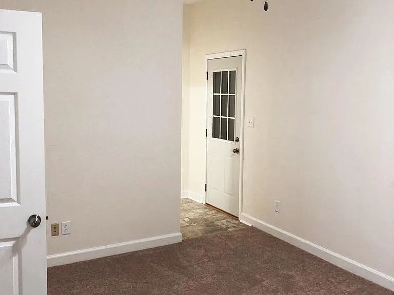 primary bedroom looking at bathroom and door to private deck to yard