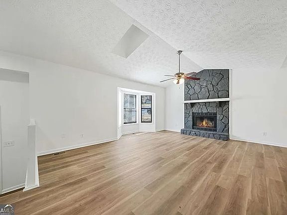 Spacious and open family room with dramatic fireplace and vaulted ceiling.