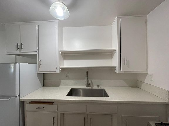White upgraded kitchen with stainless sink; comes with refrigerator