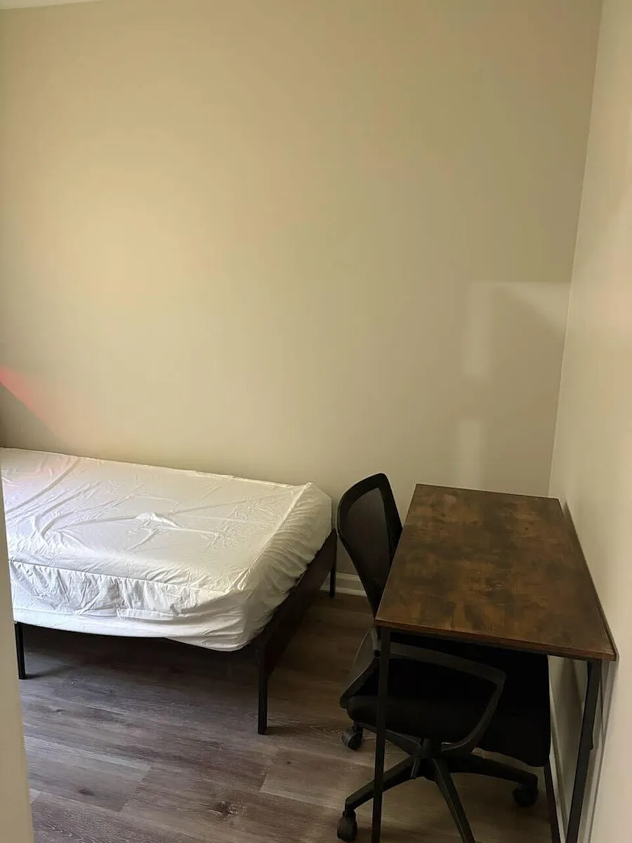 Private bedroom set up with a bed and dedicated desk area for studying or remote work, plus durable flooring. - Brown Bridge Rd