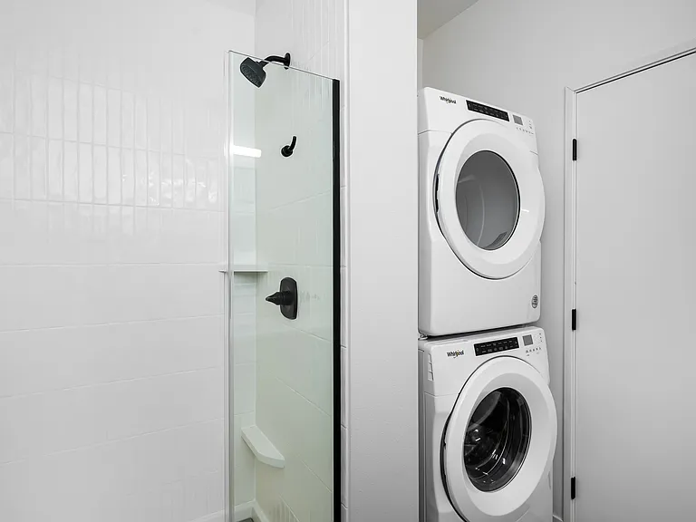 Chic modern bathroom with a sleek glass shower and convenient in-unit stacked washer and dryer. Chic modern bathroom with a sleek glass shower and convenient in-unit stacked washer and dryer.