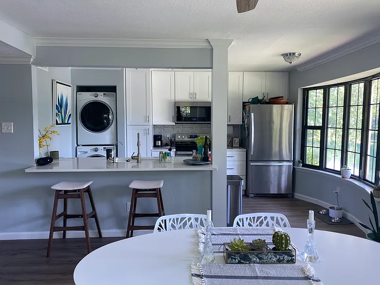 View of kitchen with new stainless steel appliances and included washer and dryer set-up.