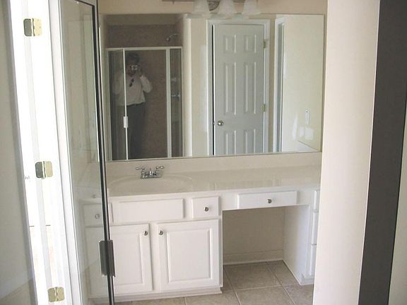 Master Bathroom showing cabinet, shower an door to private WC