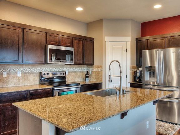 Great kitchen with slab granite island & full tile backsplash.