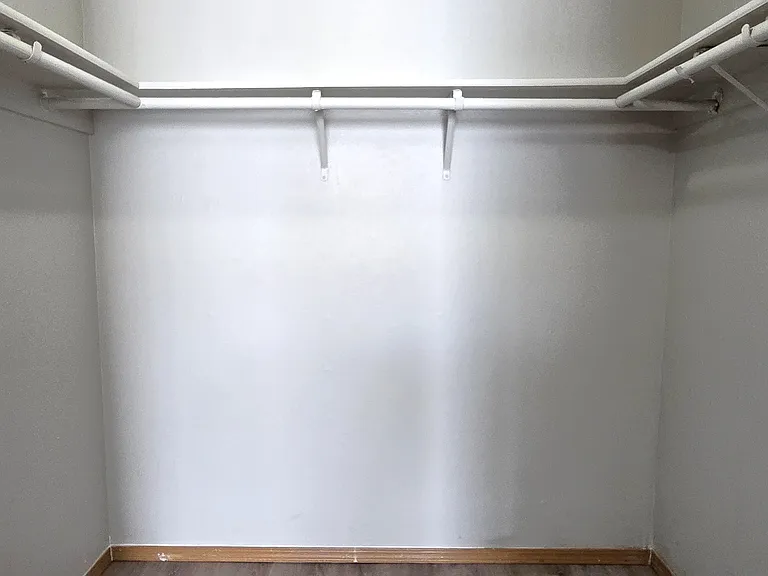 Spacious master walk-in closet with dual hanging rods and ample storage space, offering an organized and functional layout for your wardrobe.