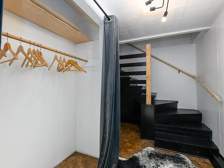 Entry way of apartment with coat closet. Stair lead up to living spaces
