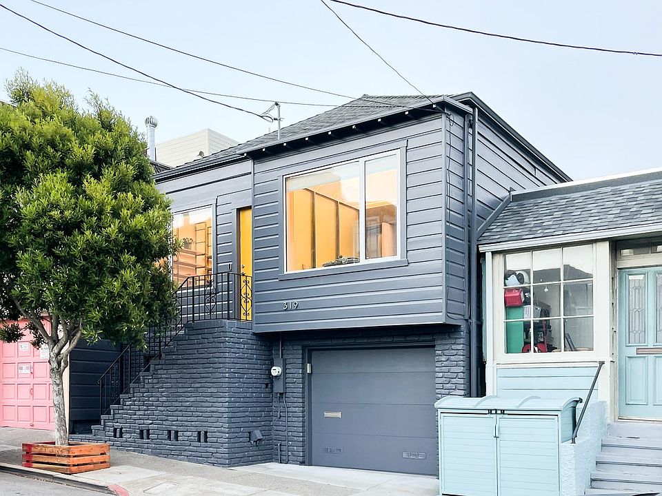 Home facing Gates Street with first story garage door, second story entry, and thriving street tree