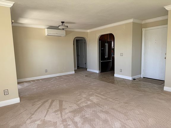 Living room view of Mitsubishi heater, dehumidifier, and air conditioner, hallway entrance, kitchen entrance, front door.